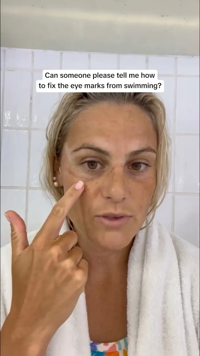 Swimmer pointing at the goggle marks under her eyes, asking how to fix them